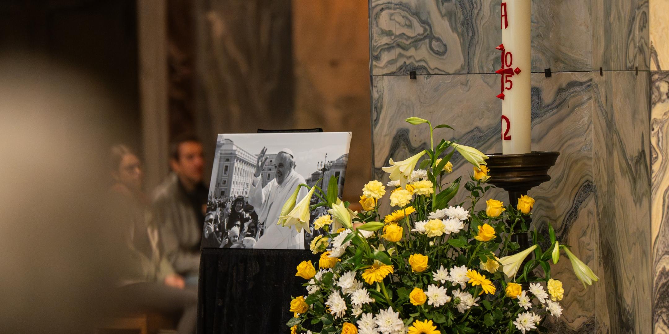 Bild von Papst Franziskus neben einer Osterkerze, vor einer Säule im Aachener Dom