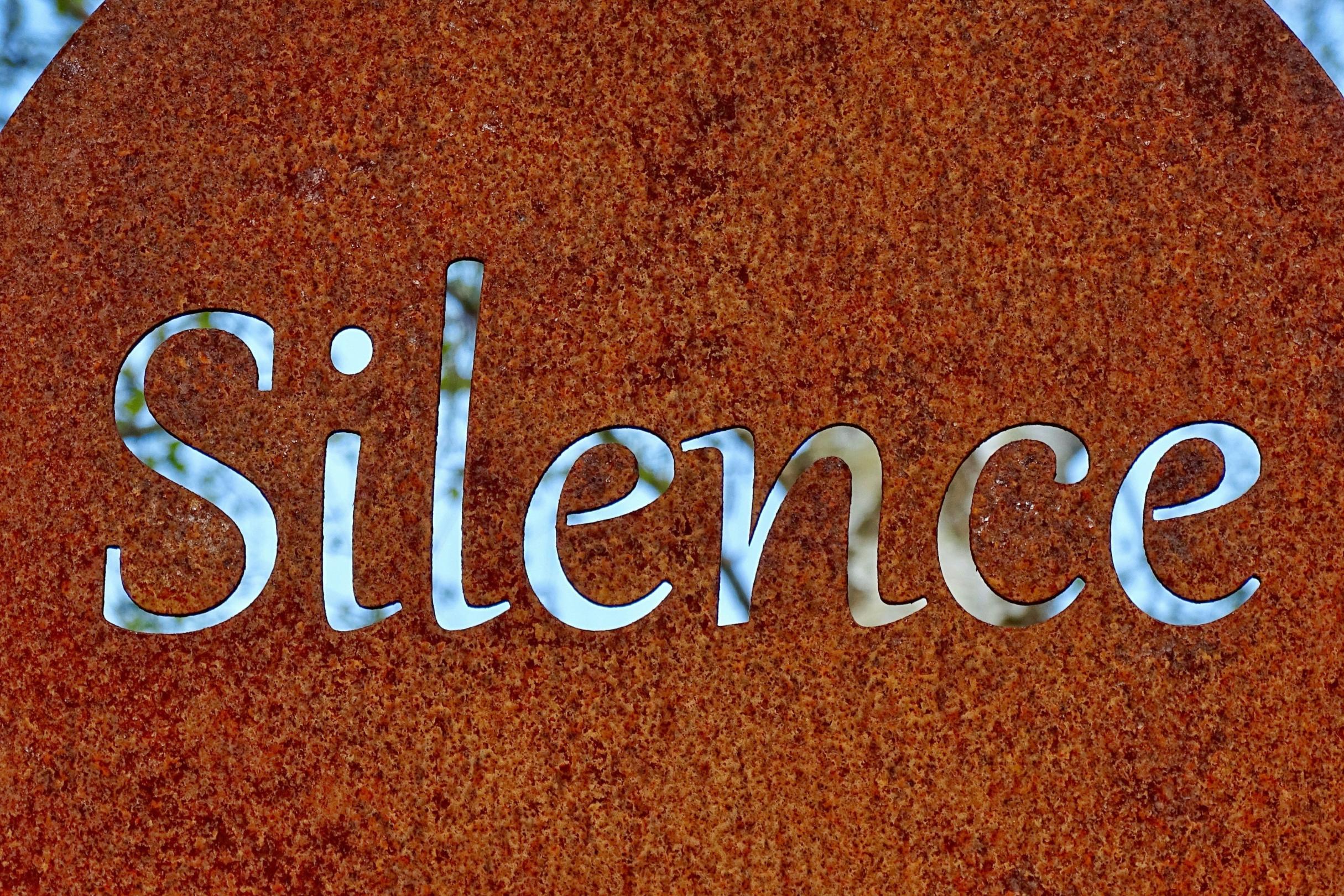rostiges Schild mit dem Wort Silence (übersetzt Stille)