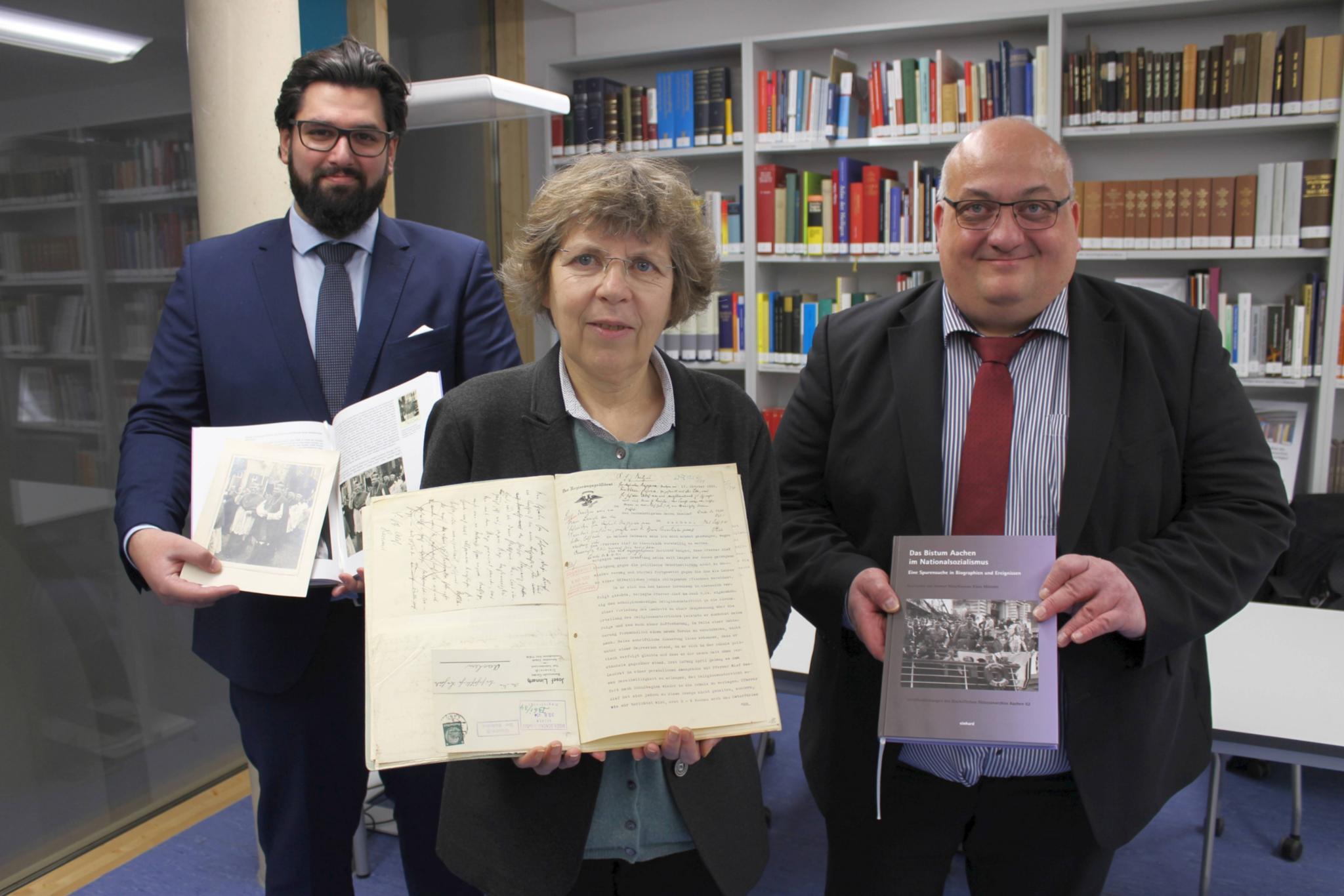 „Die Offenheit des Bistums und die gute Zusammenarbeit haben die Grundlagenforschung für dieses Projekt wirklich fruchtbar gemacht“, betonen die beiden Historiker beim Landschaftsverband Rheinland (LVR), Dr. Helmut Rönz (r.) und Keywan Klaus Münster (l.). Sie präsentieren das Buch gemeinsam mit Dr. Beate Sophie Fleck (M.), Direktorin des Diözesanarchivs Aachen.
