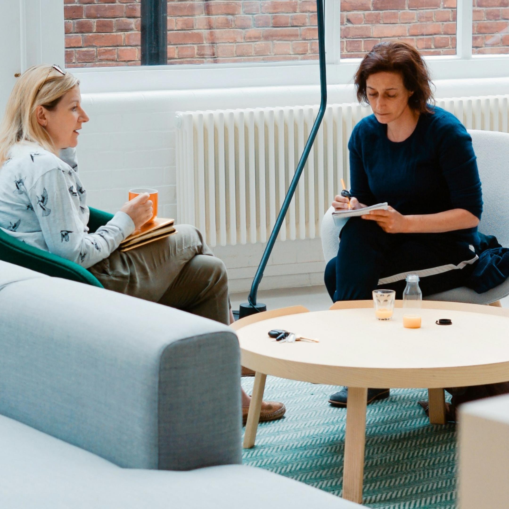 Dialogsituation zwischen zwei Frauen in einem großen Büro, Beratung, Schulung