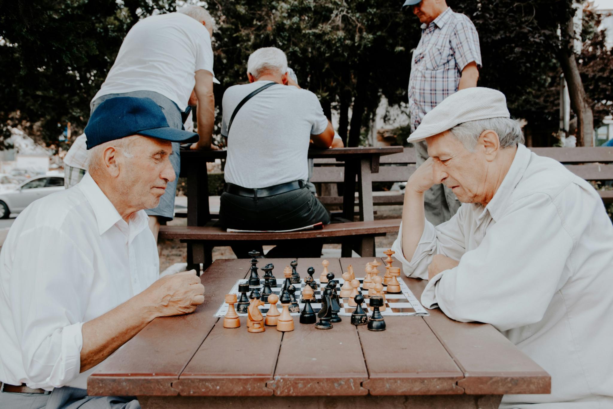 Zwei hochaltrige Männder spielen Schach zusammen