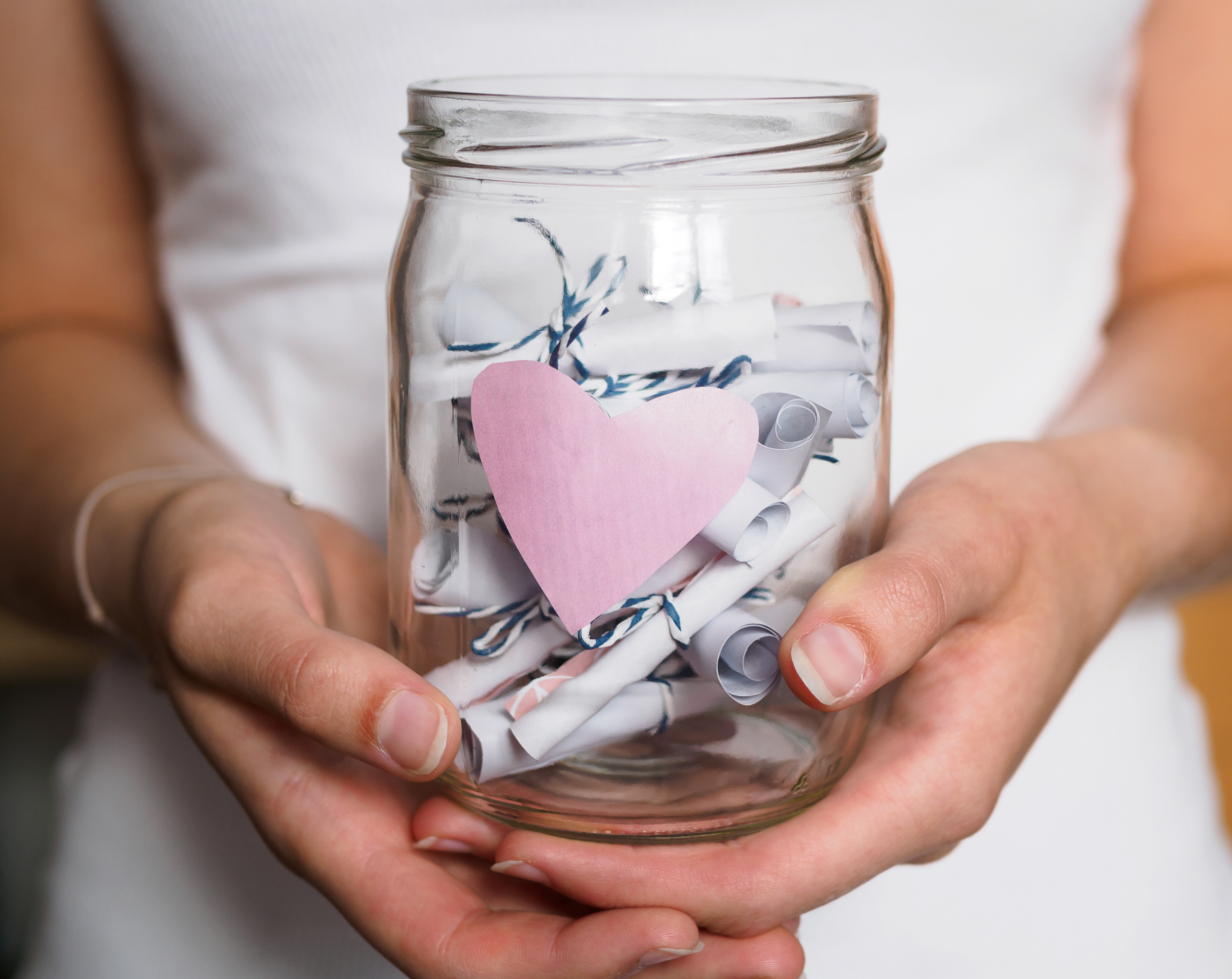 Kind hält Einmachglas mit zetteln in der Hand