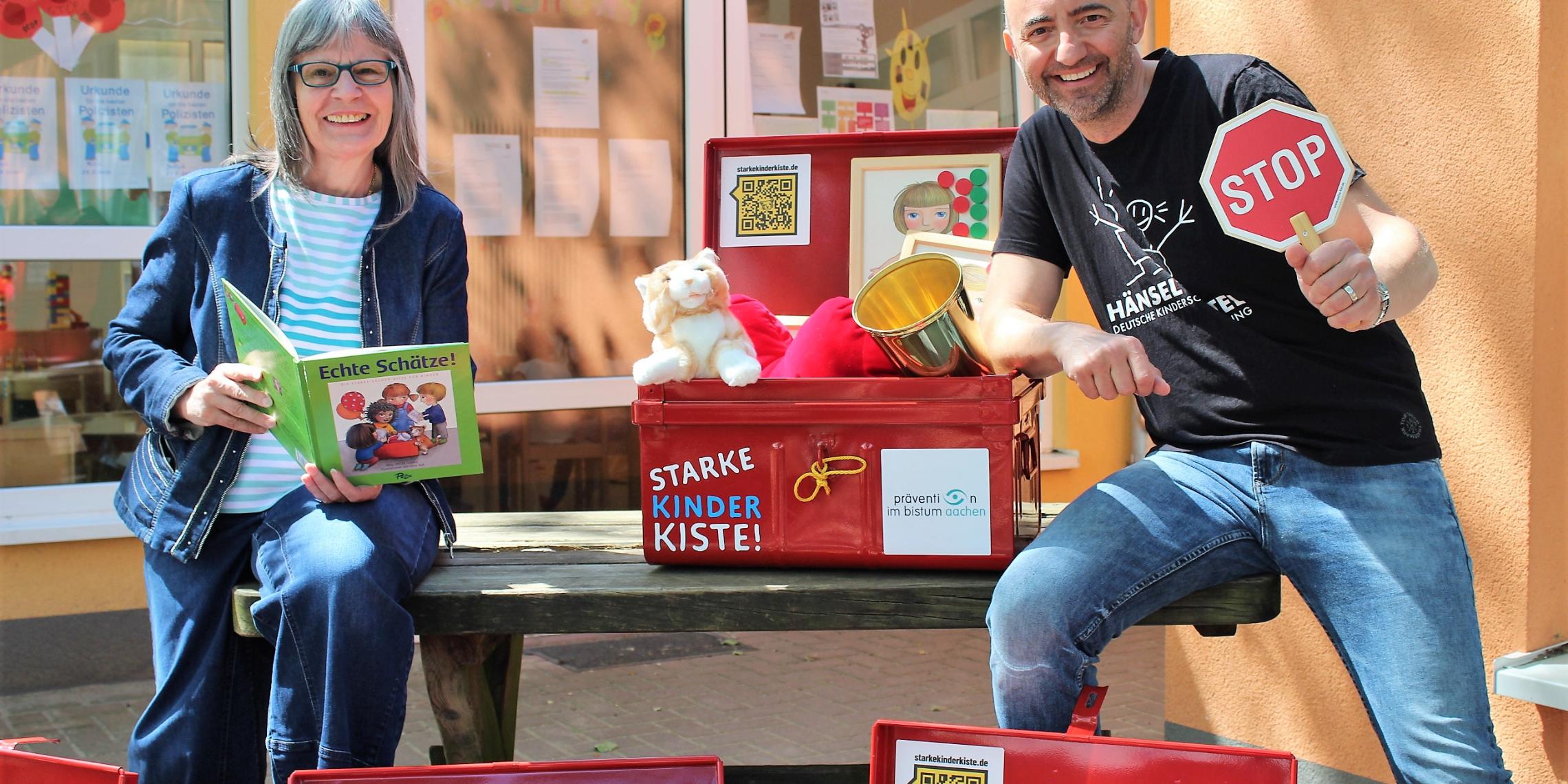 Almuth Grüner, Präventionsbeauftragte beim Bistum Aachen und Jerome Braun, Geschäftsführer der Kinderschutzstiftung Hänsel + Gretel, freuen sich, dass die 'Starke Kinder Kiste!' jetzt in den Kitas des Bistums Aachen eingesetzt wird.