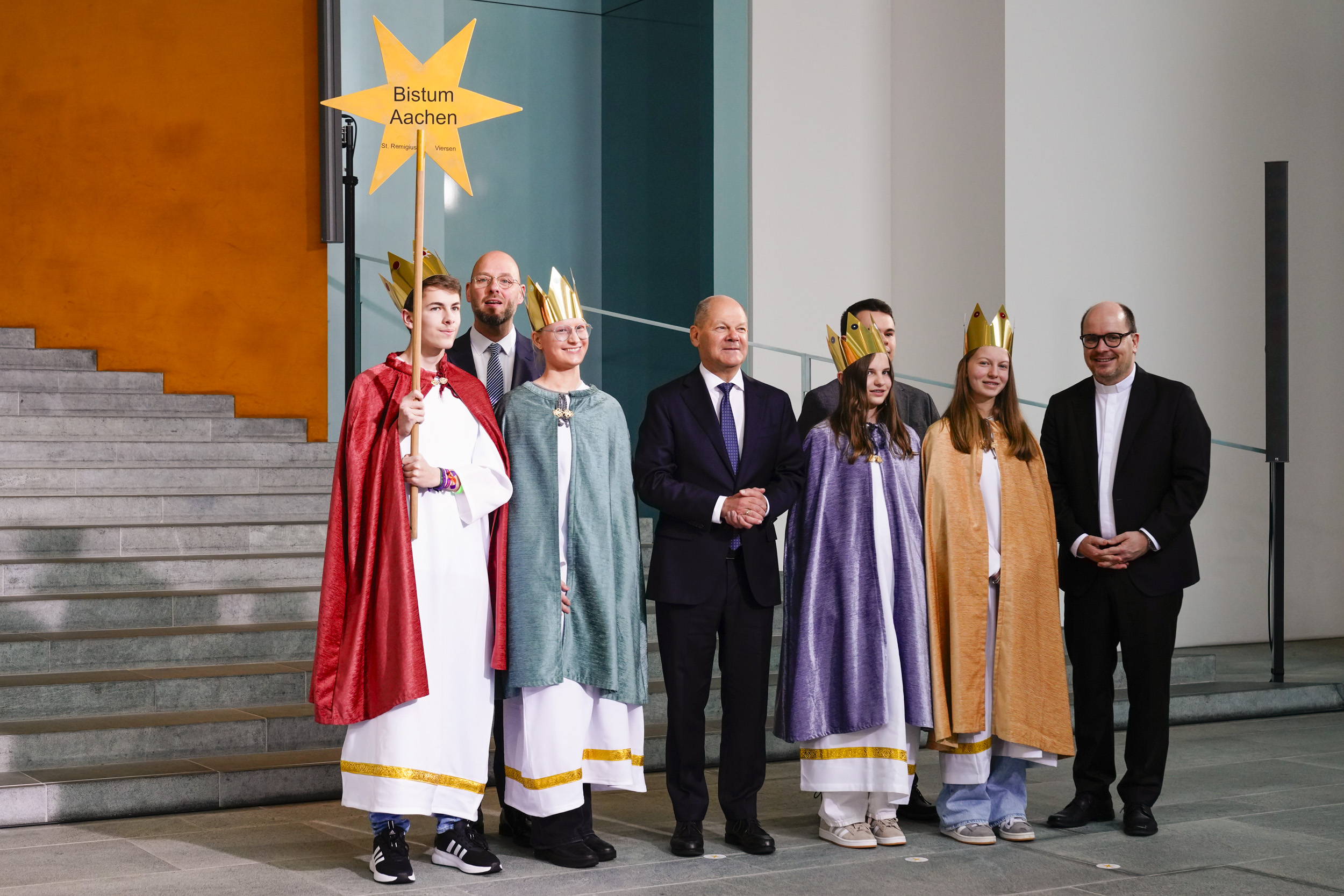 Zum Gruppenfoto mit dem Kanzler stellten sich die Sternsinger aus Viersen gemeinsam mit Pfarrer Dirk Bingener, Präsident des Kindermissionswerks ‚Die Sternsinger‘, und Domvikar Stefan Ottersbach, Bundespräses des Bundes der Deutschen Katholischen Jugend (BDKJ), im Bundeskanzleramt auf.