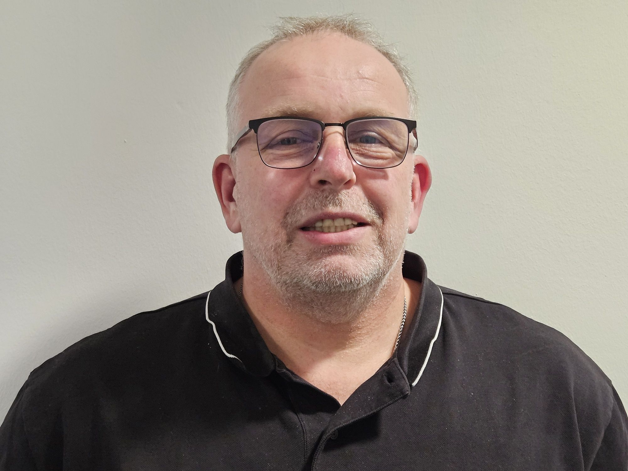 Mann, Mitte 50 mit Brille und lichtem Haar im Poloshirt