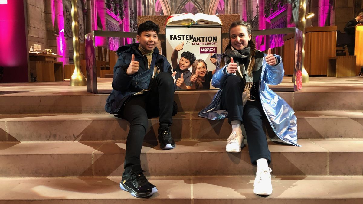 Laetizia und John-Louie, die auf dem Plakat zur Fastenaktion 2022 zu sehen sind, geben „Daumen hoch“ für jeden, der sich persönlich für eine gerechtere Welt einsetzt.