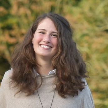 Julia_Pohl, Ehrenamtlerin mit lachendem Gesicht, braunen lockigen Haaren