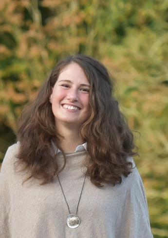 Julia_Pohl, Ehrenamtlerin mit lachendem Gesicht, braunen lockigen Haaren