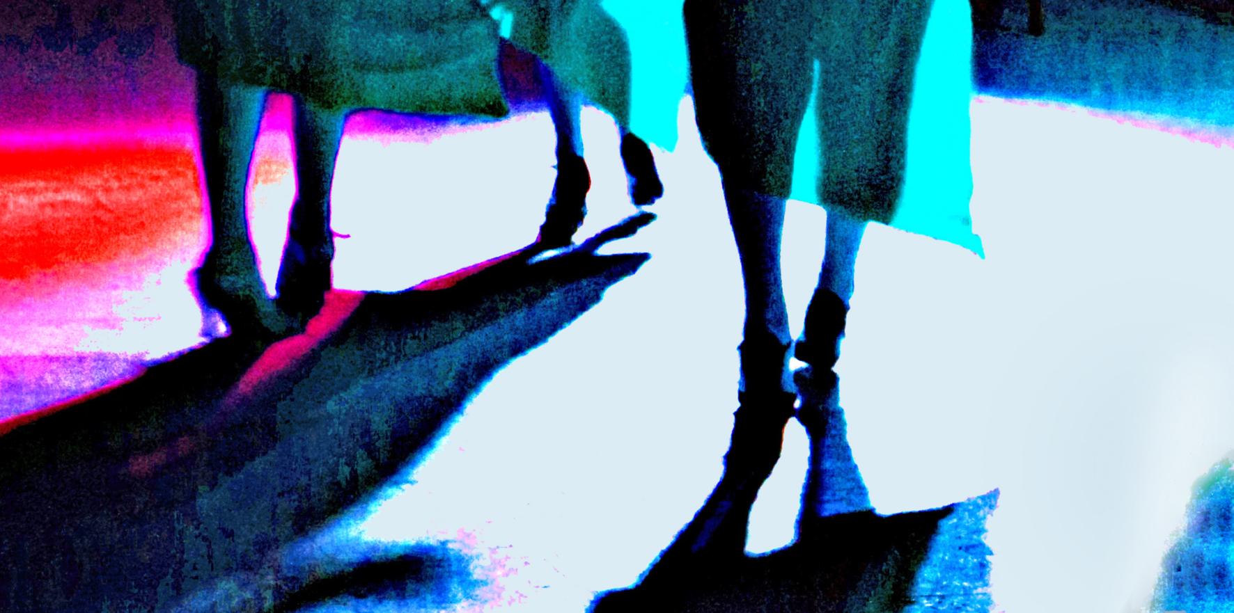 Drei Frauen, in festlicher Kleidung unterwegs, man sieht nur die Röcke und Beine von hinten.