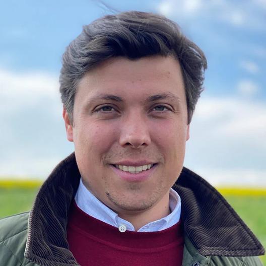 Porträt eines Mannes, es zeigt den Pfarrer Justus Geilhufe vor einer Landschaft