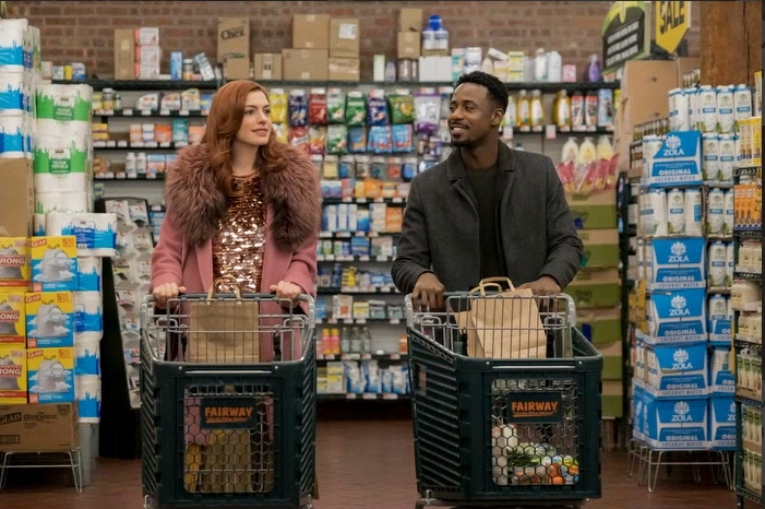 Eine Frau und ein Mann schieben jeweils einen Einkaufswagen durch einen Supermarkt.