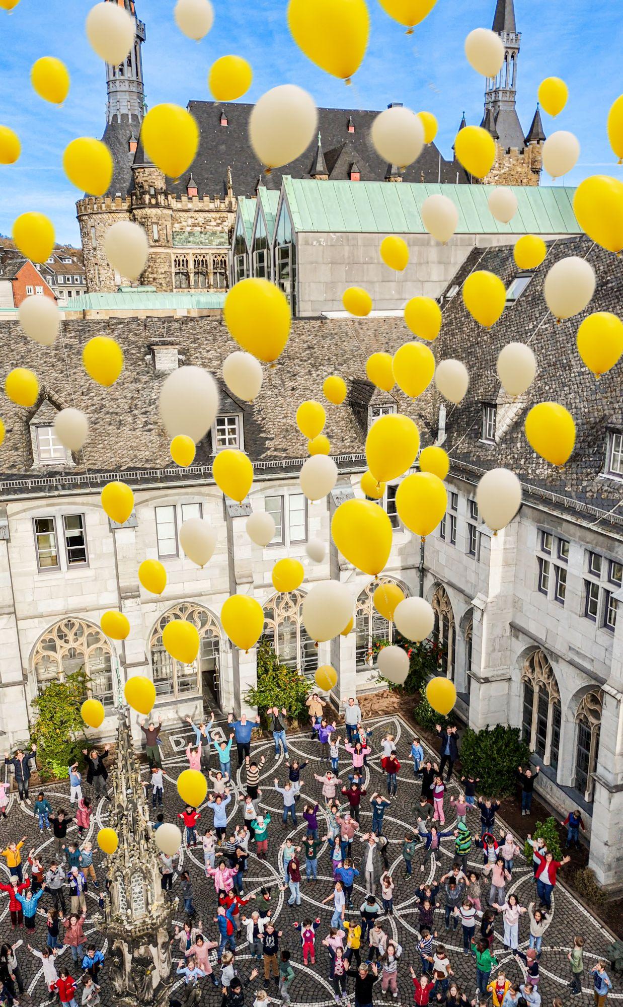 Öcher Platt im Höhenflug - die Kinder der Domsingschule feiern den Thouet-Mundartpreis mit einem bunten Luftballonstart.