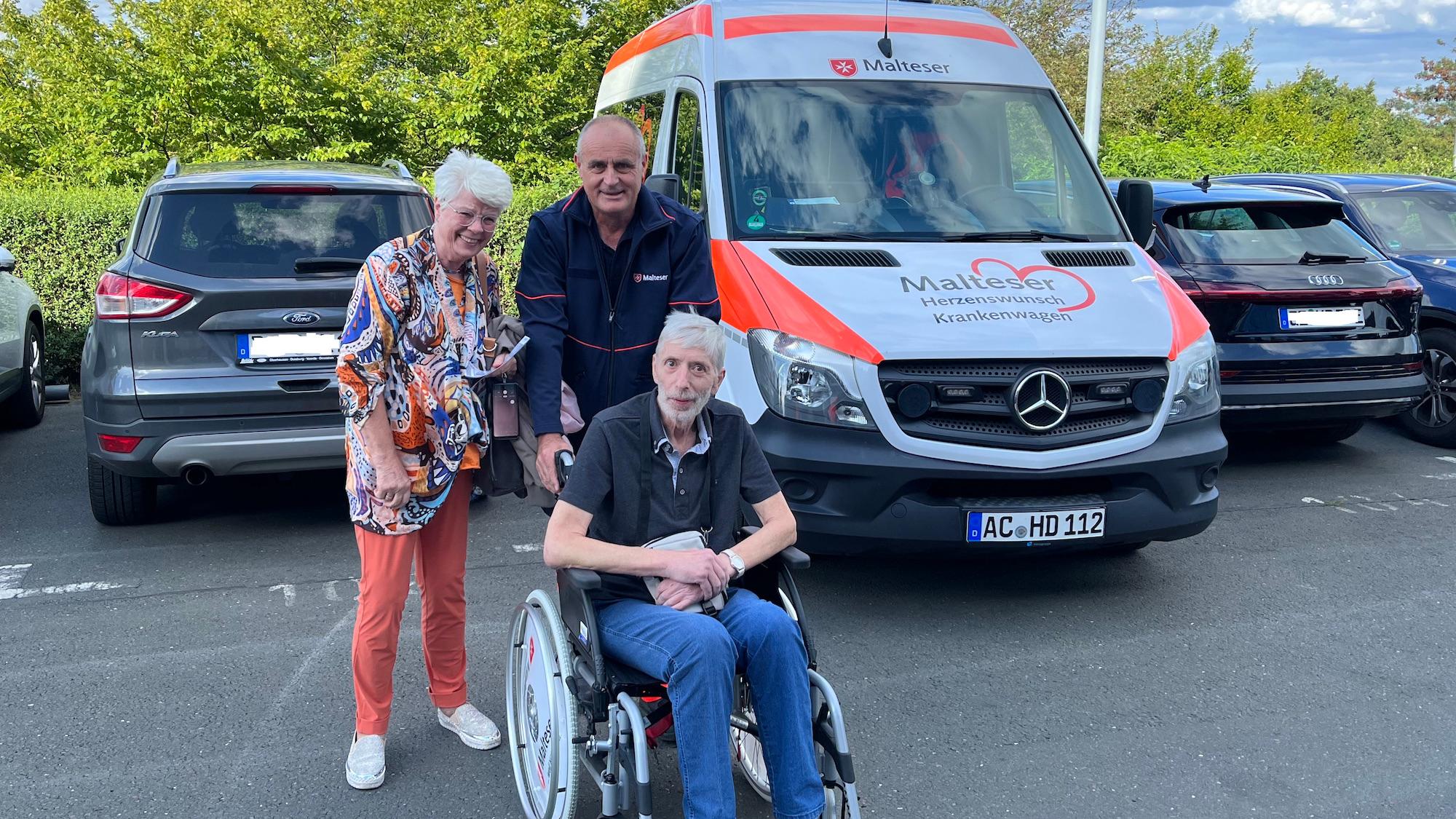 Uschi und Harald Heise mit Malteser Michael Wüster und dem Herzenswunsch-Krankenwagen.