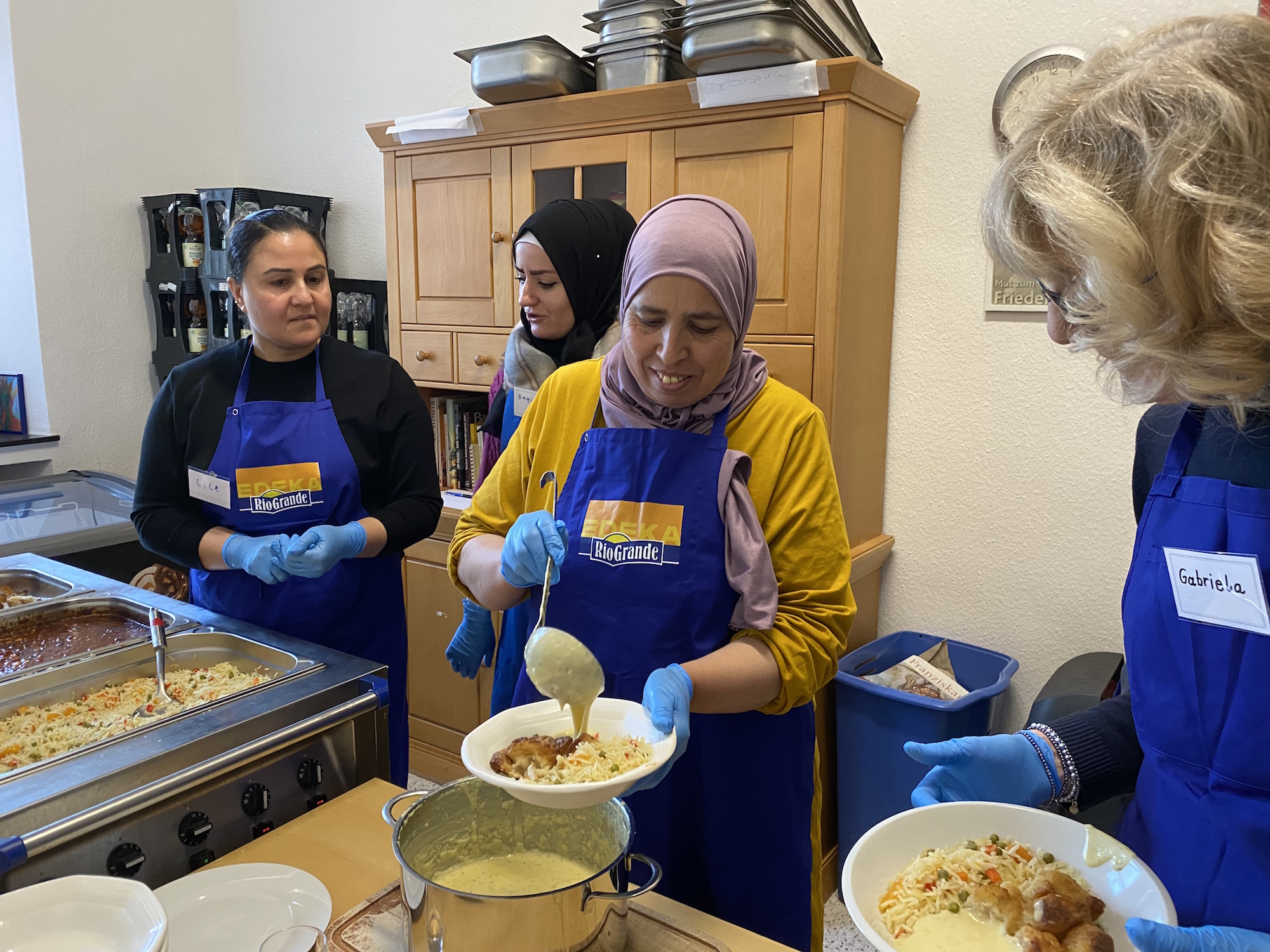 Cice, Fatima, Khadija und Gabriela (v. l.) arbeiten an der Essensausgabe Hand in Hand. Nur gemeinsam klappt es.