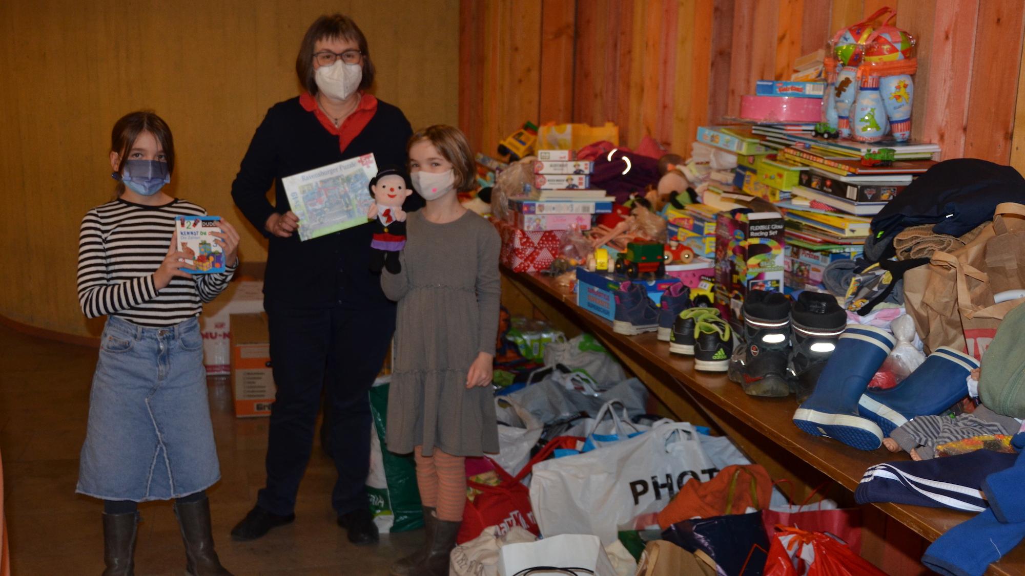 Rosa und Lily mit ihrer Schulleiterin Irma Wüller und einem Teil der Spenden der Kinder der Domsingschule.