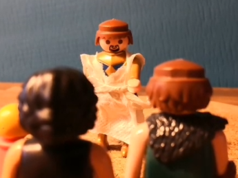 Zwei Playmobilmännchen stehen einem dritten gegenüber.