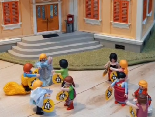 Playmobilmännchen vor einem großen Haus