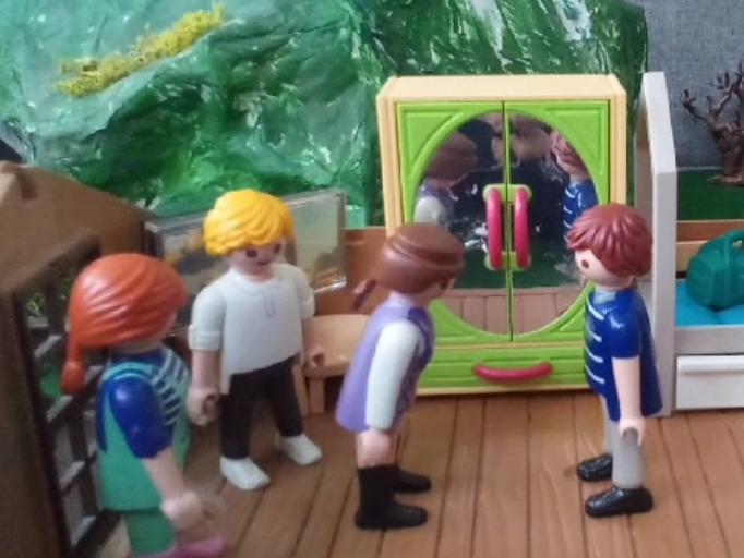 Drei Playmobilmännchen stehen vor einem vierten.