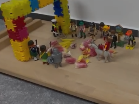 Viele Playmobilmännchen  vor einem großen Tor.