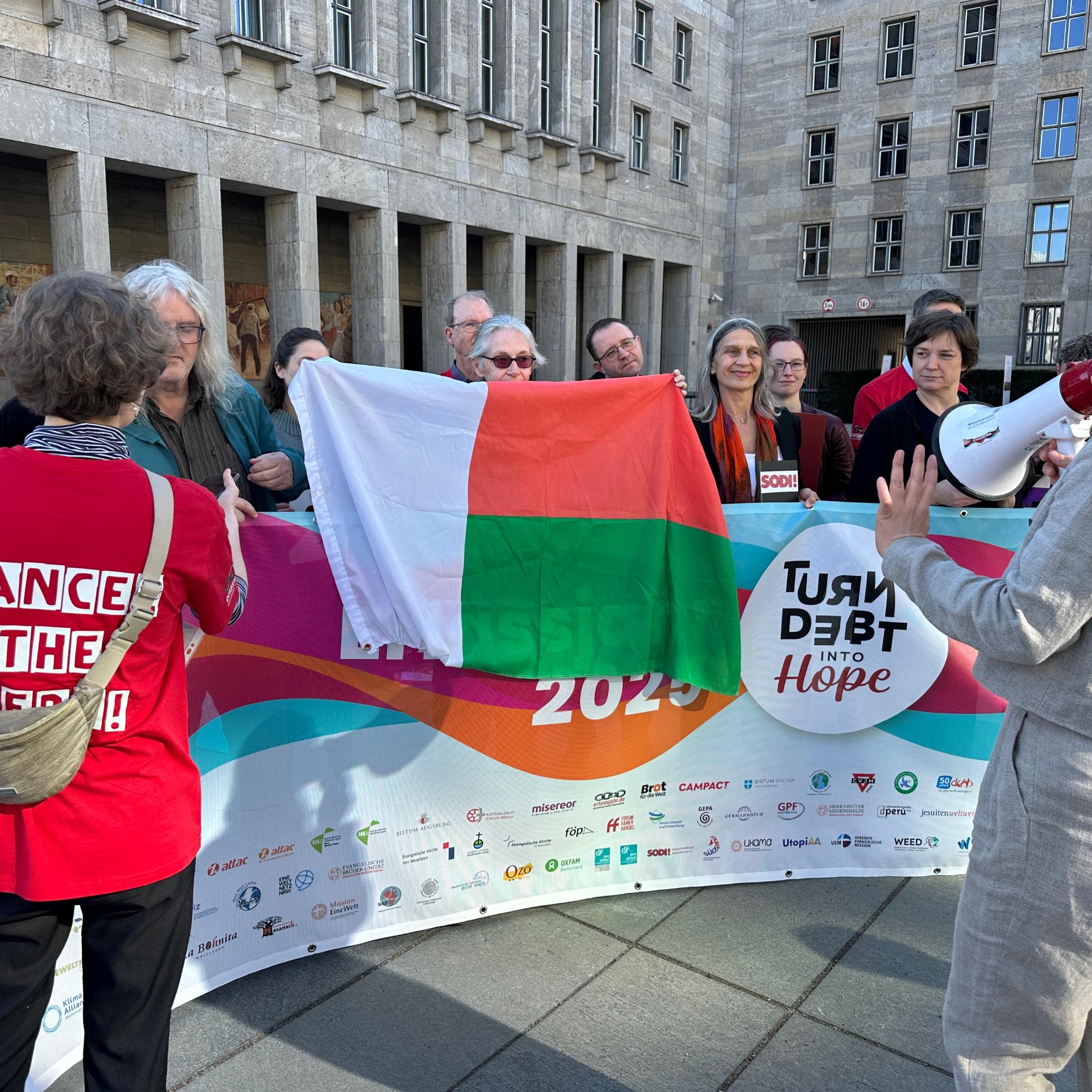 Stellvertretend für die Länder des globalen Südens haben wir die Fahne Madagaskars ins Bild gesetzt.