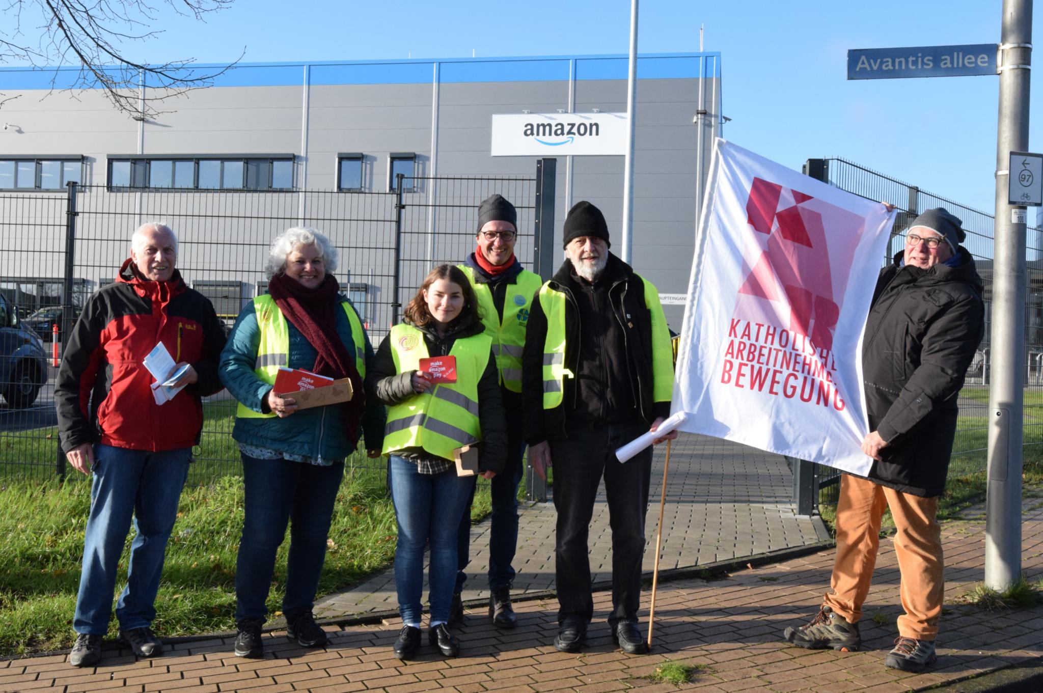 Vereinte Solidarität zum Black Friday 2022 vor dem Amazon-Verteilzentrum im Gewerbegebiet zwischen Aachen und Heerlen. Von links nach rechts: Heinz Backes, Ursula Rohrer, Anna Schlecht, Dr. Manfred Körber, Andris Gulbins und Hans-Werner Quasten.